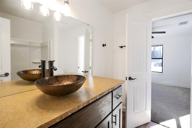 bathroom with vanity, baseboards, and visible vents