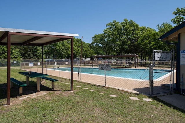 community pool with a yard and fence
