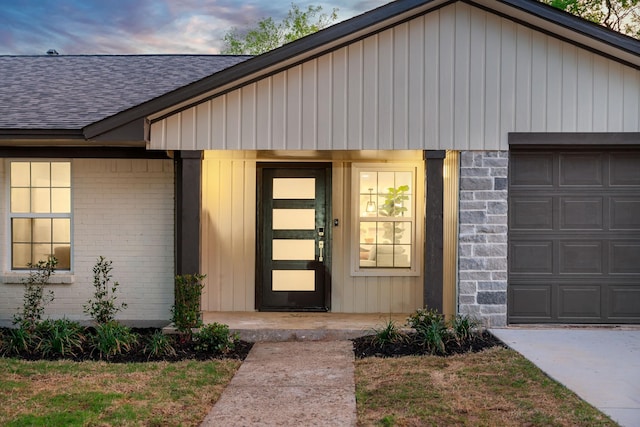 9035 Leaside Dr, Dallas, TX 75238 - entrance to property with roof with shingles, an attached garage, and brick siding