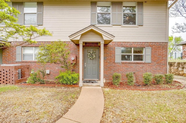 traditional-style house with brick siding and a front yard