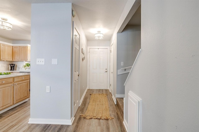 hallway featuring light wood-style floors and baseboards