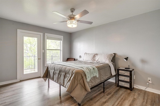 bedroom with baseboards, a ceiling fan, wood finished floors, and access to exterior