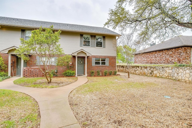 view of front of property with brick siding and a front lawn