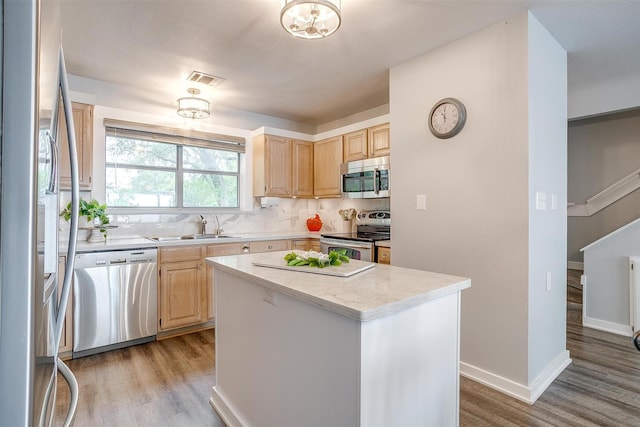 kitchen featuring light countertops, appliances with stainless steel finishes, light brown cabinets, and a sink