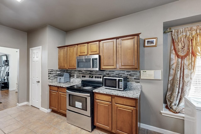kitchen featuring visible vents, arched walkways, appliances with stainless steel finishes, and decorative backsplash
