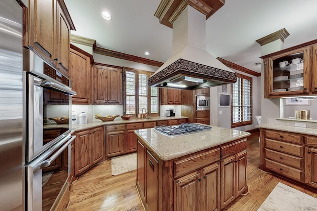 931 Willow Ct, Fairview, TX 75069 - kitchen featuring island range hood, appliances with stainless steel finishes, crown molding, light wood-style floors, and a sink