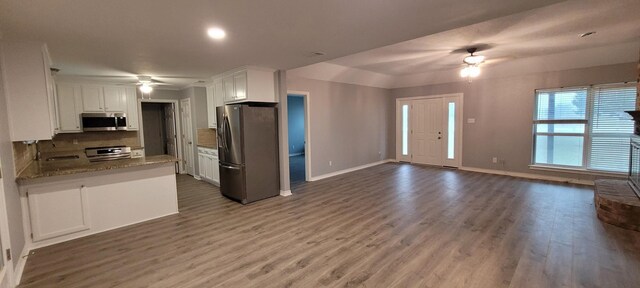 295 Goodnight Trl, Rhome, TX 76078 - kitchen featuring white cabinetry, tasteful backsplash, open floor plan, stainless steel appliances, and ceiling fan