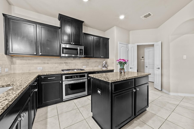 kitchen with visible vents, backsplash, dark cabinetry, and appliances with stainless steel finishes
