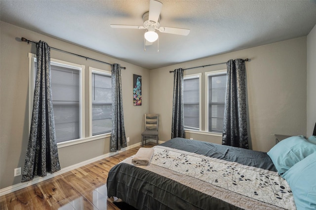 1112 Berkley Ave, Dallas, TX 75224 - bedroom featuring wood finished floors, baseboards, ceiling fan, and a textured ceiling