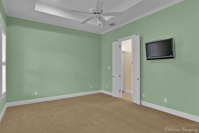 carpeted empty room featuring baseboards, a ceiling fan, crown molding, and plenty of natural light