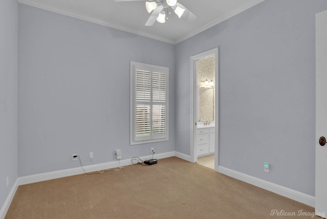empty room featuring light colored carpet, crown molding, baseboards, and a ceiling fan