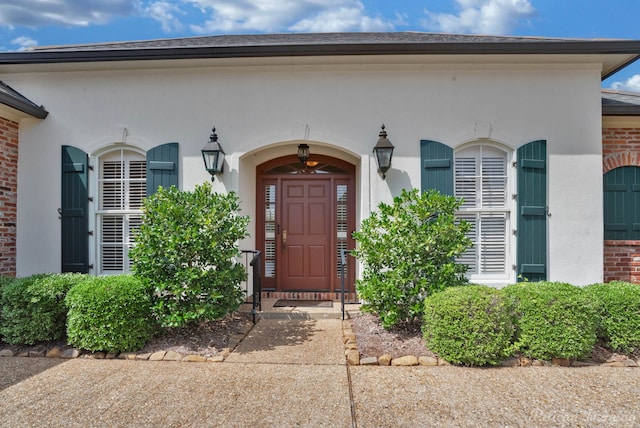 entrance to property with brick siding and stucco siding