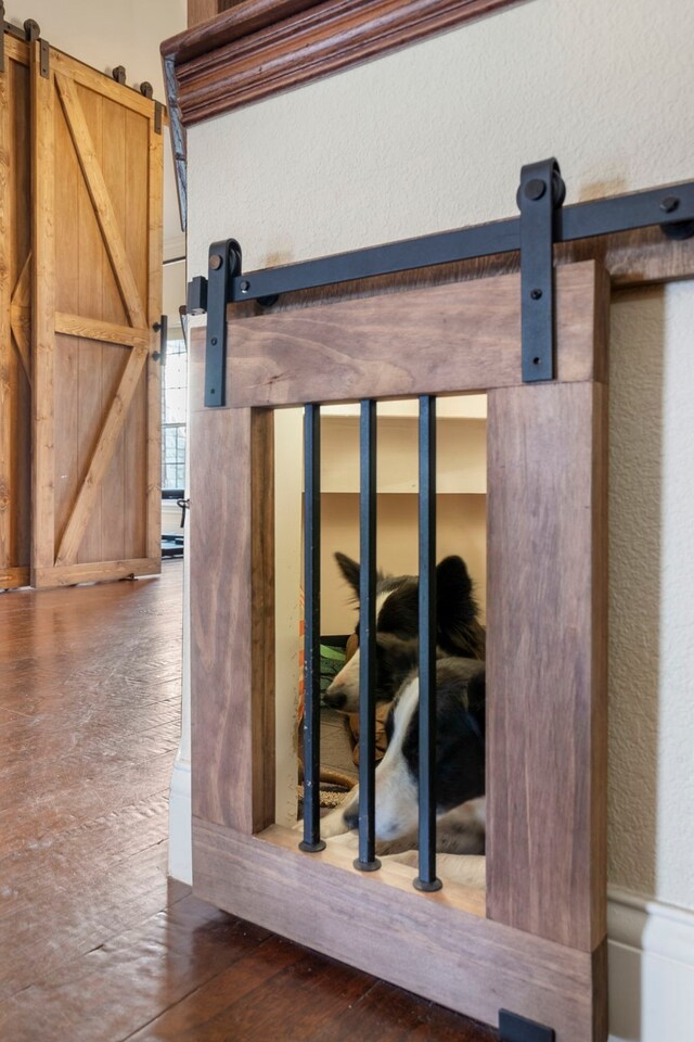 room details with a barn door and wood finished floors