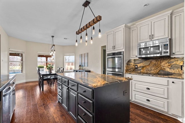 kitchen featuring white cabinets, stainless steel appliances, a center island, and tasteful backsplash