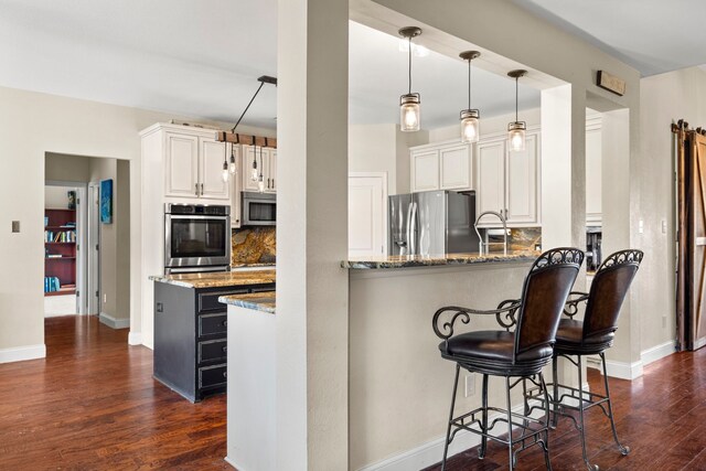 kitchen featuring stainless steel appliances, dark wood finished floors, backsplash, white cabinets, and light stone countertops