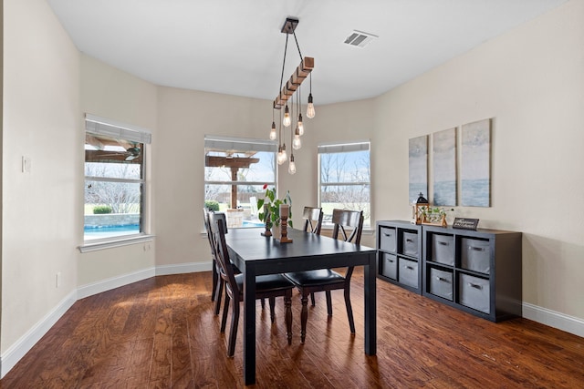 dining room featuring baseboards, a wealth of natural light, visible vents, and wood finished floors