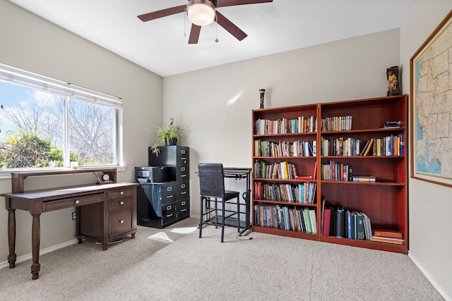 carpeted office featuring a ceiling fan and baseboards