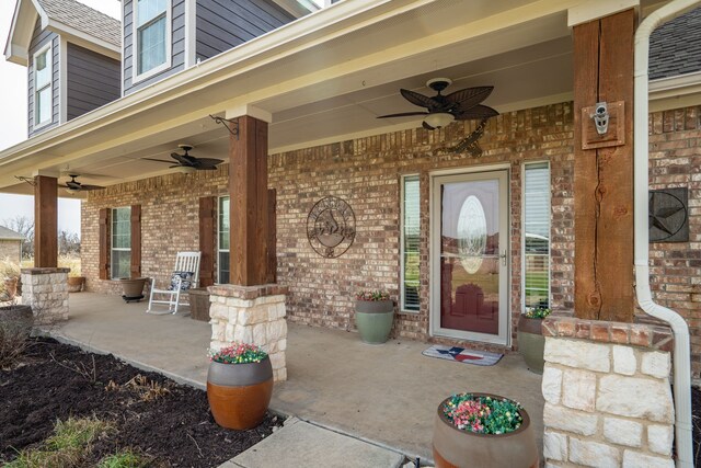 doorway to property with a porch, brick siding, and a ceiling fan