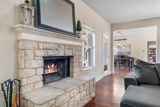 living room featuring baseboards, a fireplace, and hardwood / wood-style flooring