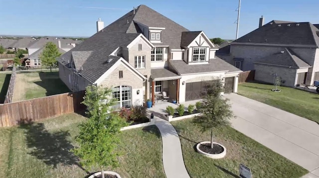 view of front of house featuring fence, roof with shingles, a front lawn, a garage, and concrete driveway