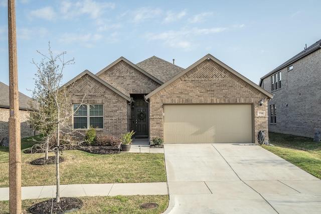 3708 Bluestem Blvd, Denton, TX 76226 - view of front of property with a front yard, roof with shingles, brick siding, concrete driveway, and an attached garage