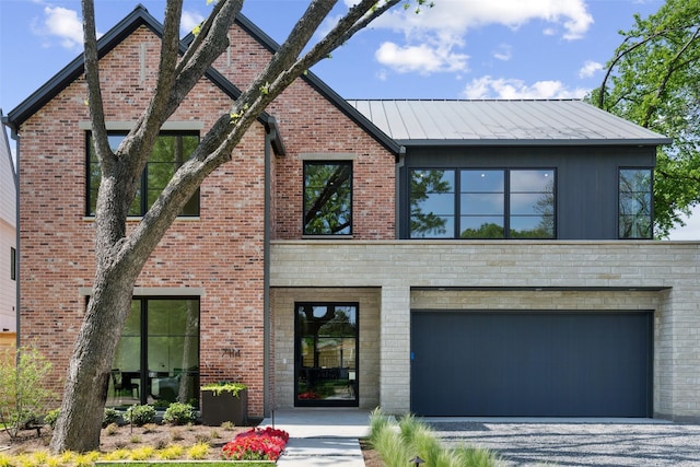 view of front of home featuring brick siding, driveway, and a standing seam roof