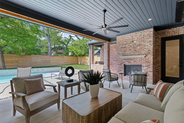 view of patio / terrace with a ceiling fan, a fenced in pool, an outdoor hangout area, a fenced backyard, and an outdoor kitchen
