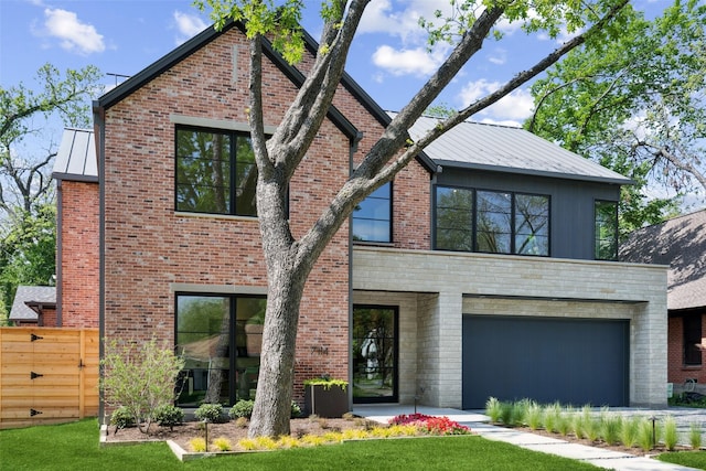 view of front facade featuring brick siding, a standing seam roof, metal roof, and a front yard