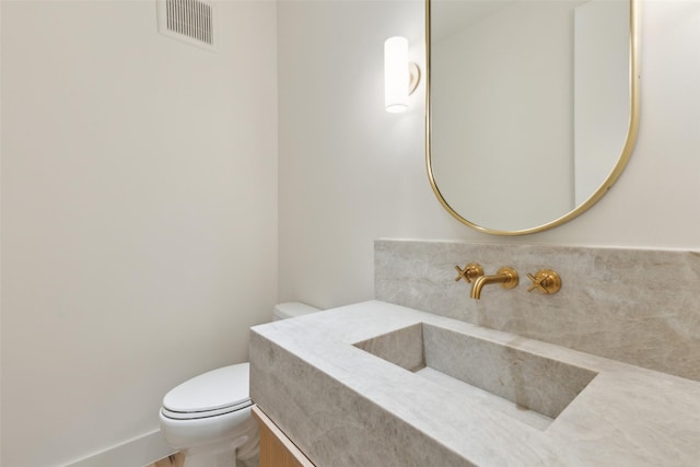 bathroom with visible vents, toilet, and vanity
