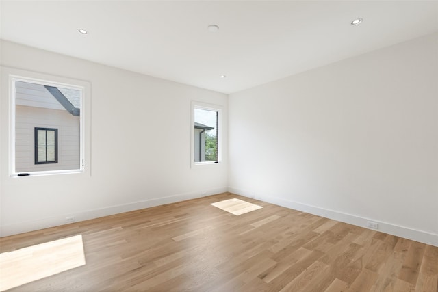 unfurnished room featuring recessed lighting, baseboards, and light wood-type flooring