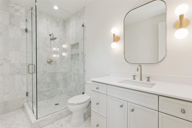 bathroom featuring toilet, a marble finish shower, and vanity