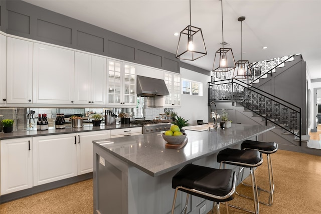 kitchen with white cabinets, range, tasteful backsplash, and ventilation hood
