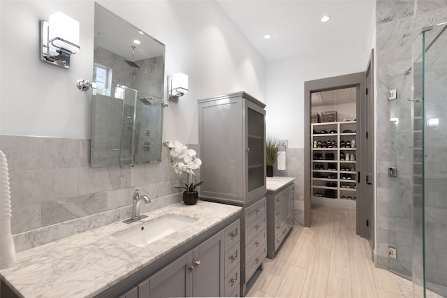 full bathroom featuring vanity, tile walls, recessed lighting, a spacious closet, and a shower stall