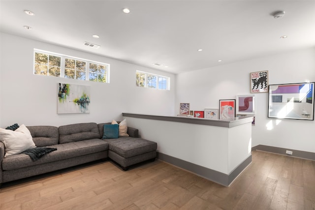 living room with visible vents, baseboards, recessed lighting, and wood finished floors
