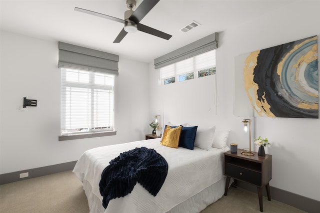 carpeted bedroom featuring baseboards, visible vents, and a ceiling fan