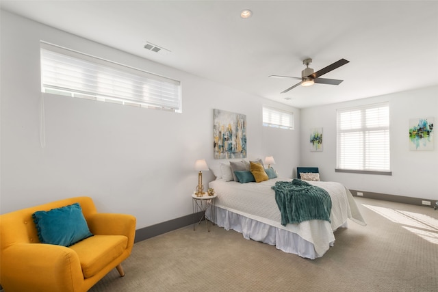 carpeted bedroom with baseboards, ceiling fan, and visible vents