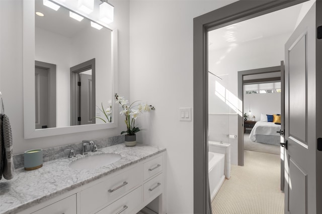 bathroom with a tub, vanity, tile patterned flooring, and ensuite bathroom