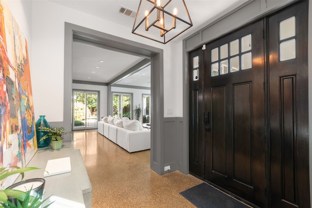entryway featuring a wainscoted wall, speckled floor, visible vents, recessed lighting, and an inviting chandelier
