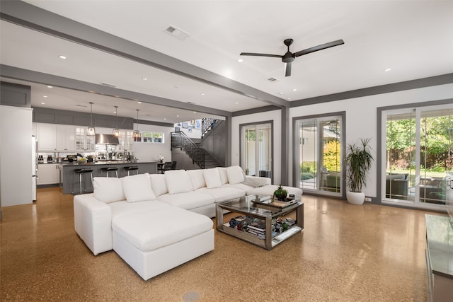 living room with a ceiling fan, speckled floor, stairway, and visible vents
