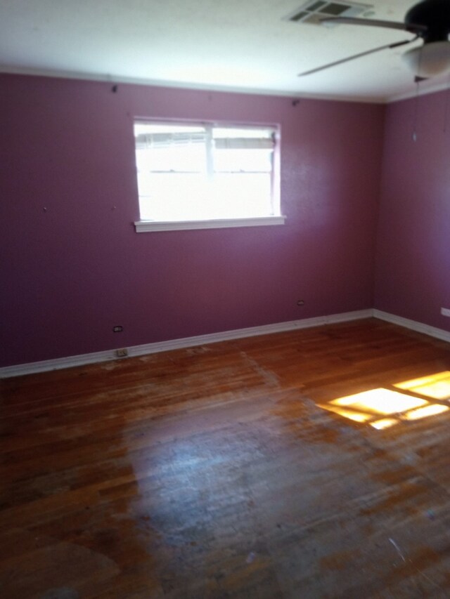 spare room with baseboards, ceiling fan, and wood finished floors