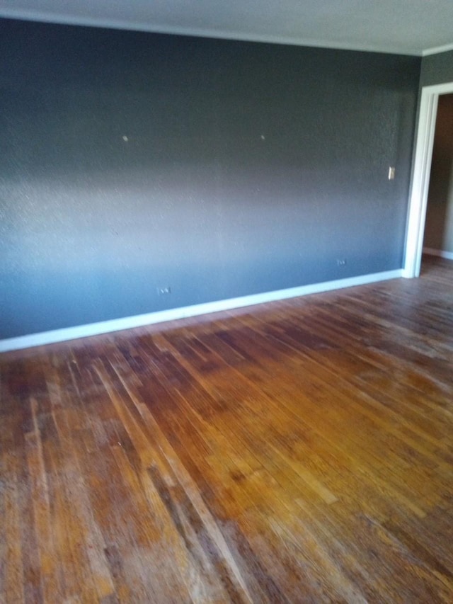 empty room featuring baseboards and wood finished floors