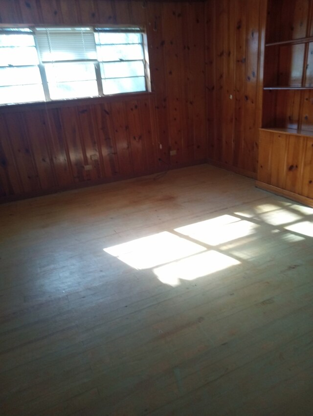 spare room with wooden walls and light wood-style floors