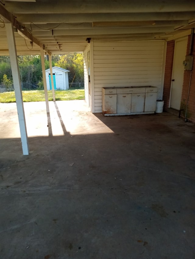 view of patio featuring an attached carport, an outdoor structure, and a storage shed