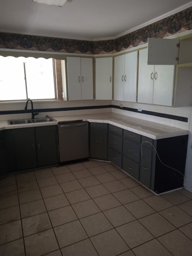 kitchen featuring light countertops, a sink, tile patterned flooring, and stainless steel dishwasher