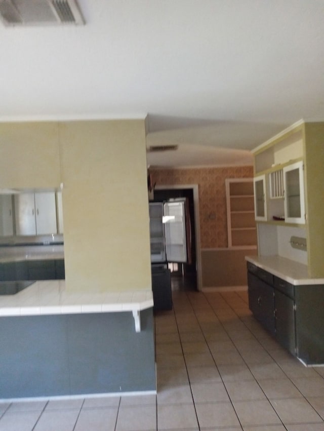 kitchen featuring tile countertops, visible vents, and light tile patterned floors