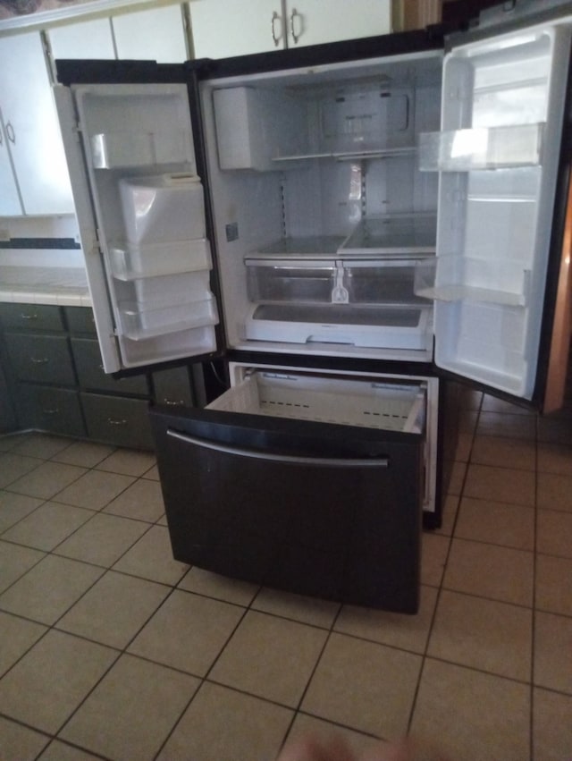 kitchen with fridge and light tile patterned floors