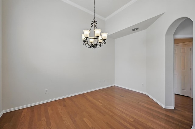 unfurnished room with visible vents, wood finished floors, arched walkways, and an inviting chandelier