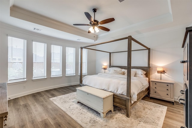 bedroom featuring visible vents, wood finished floors, and a raised ceiling