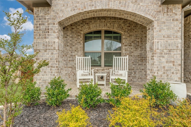 entrance to property featuring brick siding