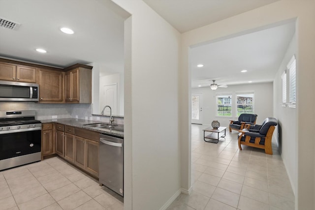 1256 Bright Stars Dr, Little Elm, TX 76227 - kitchen with appliances with stainless steel finishes, a sink, dark stone counters, recessed lighting, and baseboards